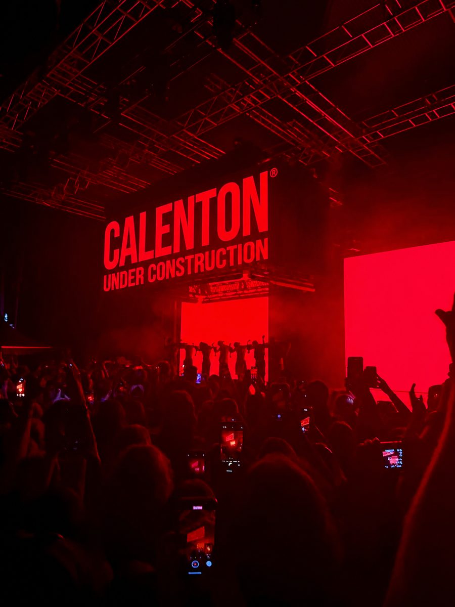 Calenton Under Construction: a packed room, phones in the air, all lit red.